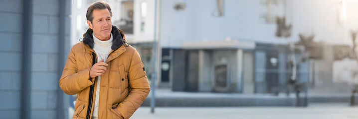 Mann mit curryfarbener Winterjacke